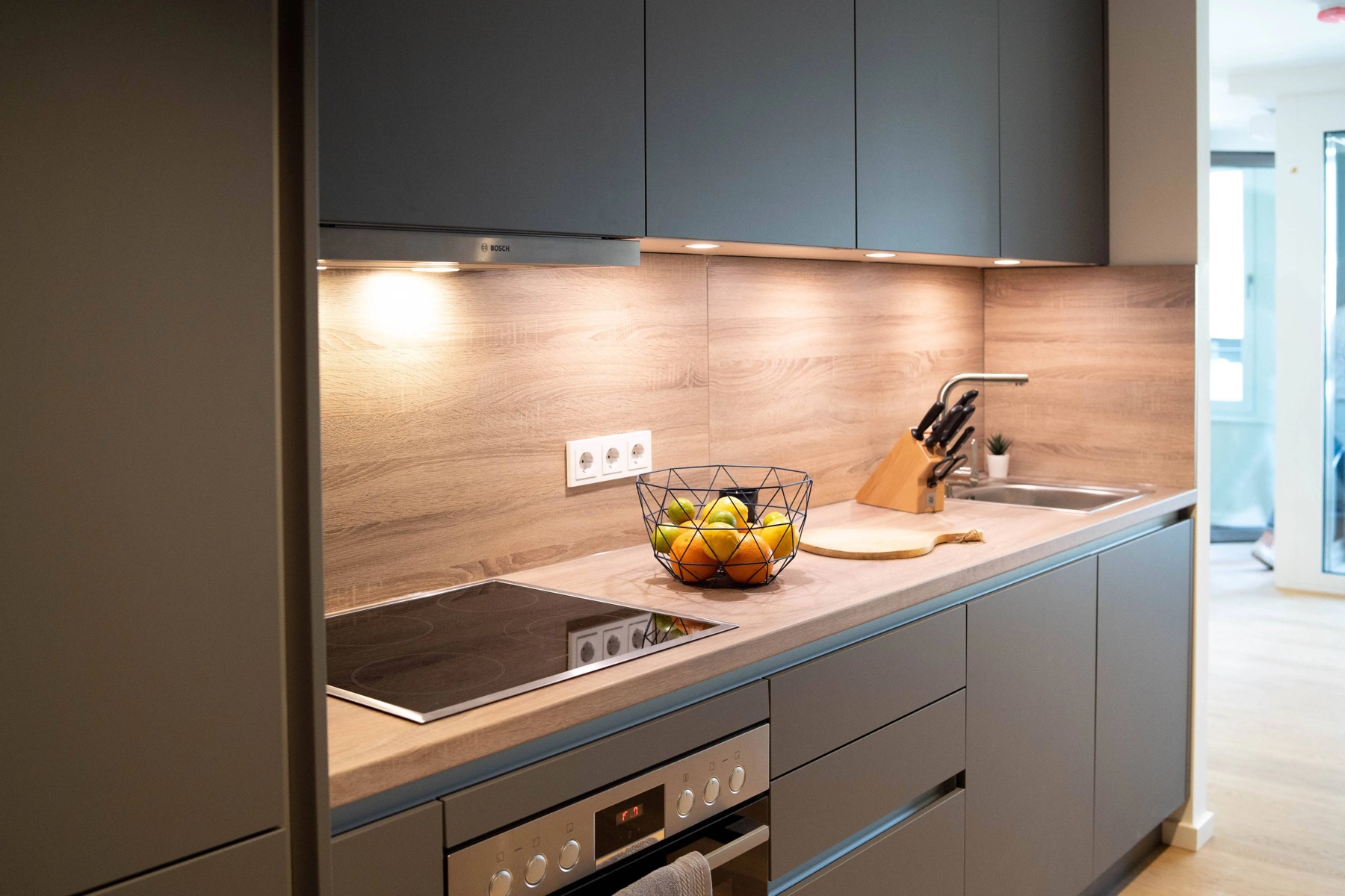 Von ROOMHERO realisierte Einbauküche in Frankfurt mit grauen Fronten und Arbeitsplatte in Holzoptik